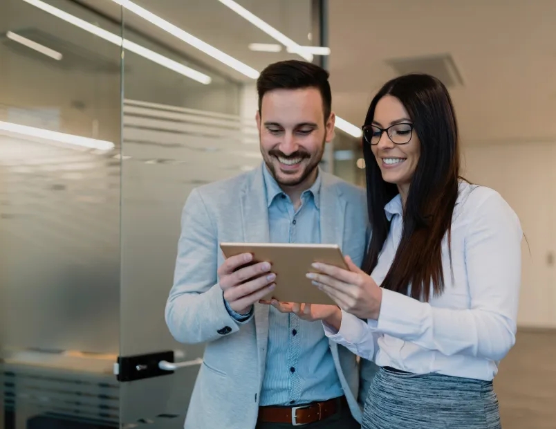 A man and woman looking at a tablet together.