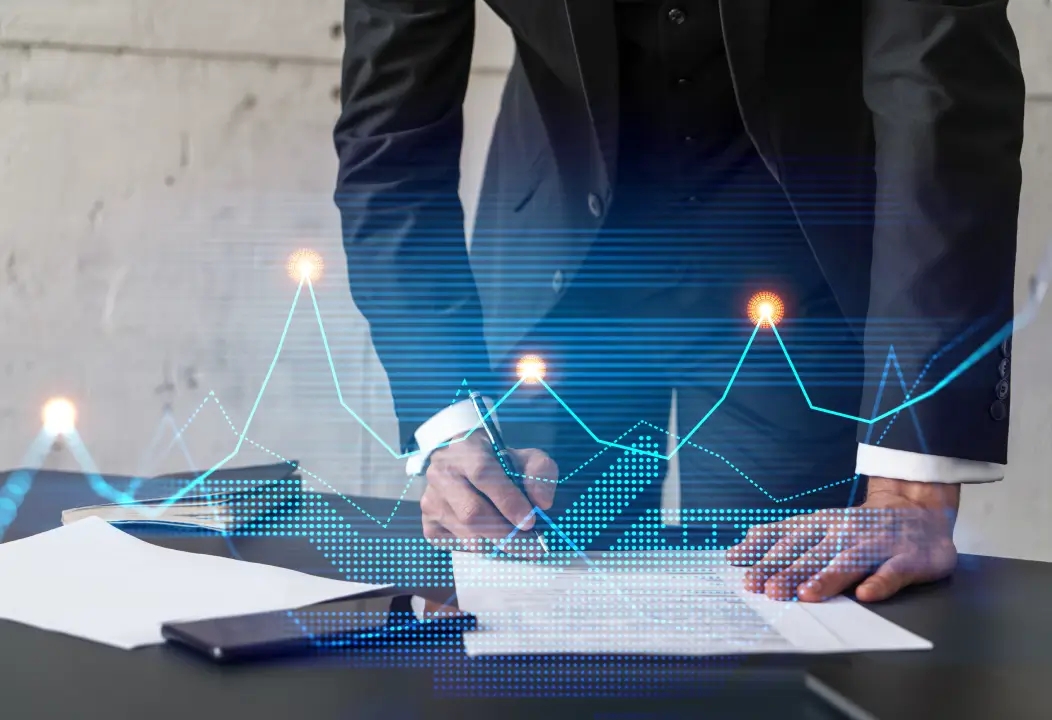 A man in a suit writing on a paper, focusing on risk management.