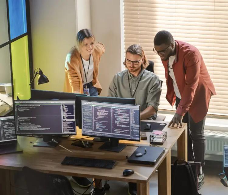 A diverse team of professionals working on computers in an office at a software testing company.