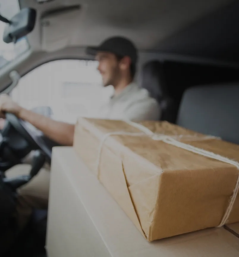A delivery van with a company logo parked in front of a warehouse, ready to transport packages efficiently.